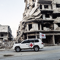 ICRC Car in front of collapsed buildings