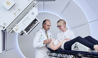 Damien Weber, Head and Chairman of the Center for Proton Therapy at PSI, demonstrates with two colleagues the patient treatment procedure at Gantry 3. (Photo: Scanderbeg Sauer Photography) 
