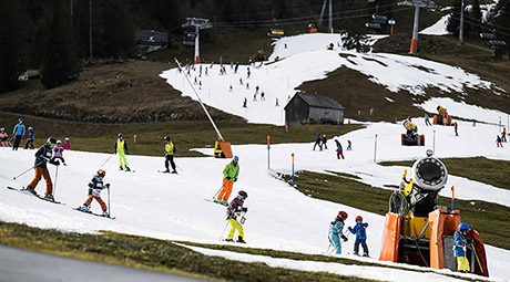  Skifahrer:innen auf einer Kunstschneepiste in grüner Landschaft, aufgenommen am 4. Januar 2023 in Wildhaus im Obertoggenburg. (Bild: KEYSTONE/Gian Ehrenzeller) 