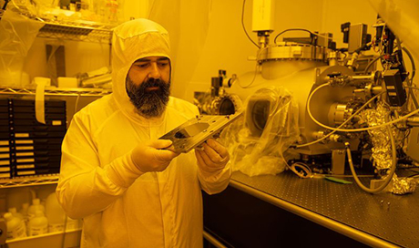 Dimitrios Kazazis in the clean room at the beamline. In his hands he is holding one of the so-called wafers processed using a new method. (Photo: Paul Scherrer Institute/Mahir Dzambegovic) 