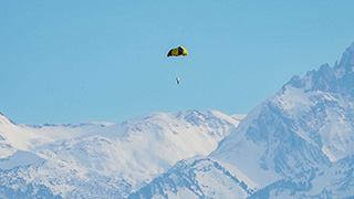 Le satellite test est en l'air devant une chaîne de montagnes (Image : Nicole Davidson / ETH Zürich). 