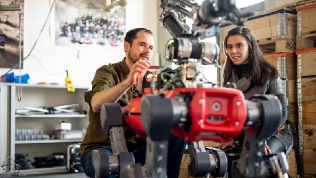 Prof. Marco Hutter and researcher Maria Vittoria Minniti with a robot